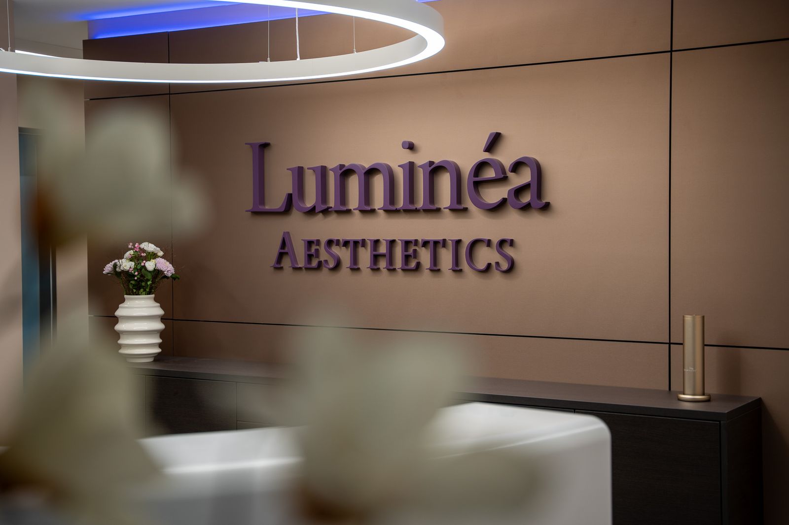 Der Empfang von Luminéa mit dem Logo an der Wand.