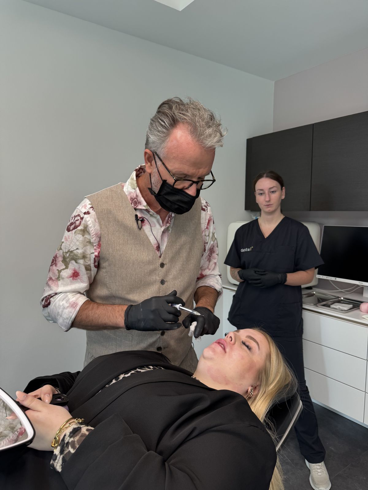 Dr. Twent behandelt eine Patientin, die entspannt im Behandlungsstuhl liegt, daneben seine Assistentin.